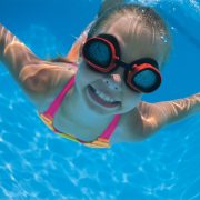 Girl with goggles swimming underwater