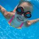 Girl with goggles swimming underwater